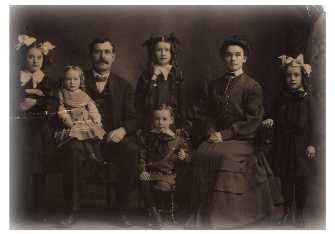 My grandmother, Lillian Katherine Quinn, is the youngest girl, pictured here sitting on her father's lap.